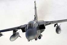 Photograph of a Tornado flying over clouds