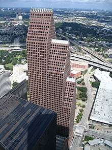Large building with three, segmented tower setbacks, each with  a steeply pitched roof line topped with a series of spires.