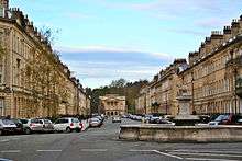 A long street of matching houses built from honey-coloured stone.