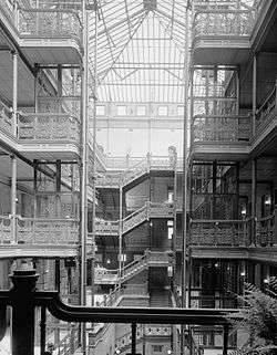 HABS interior photograph of the central court of the Bradbury Building, emphasizing the ornamental ironwork on the stairways and open walkways and the large skylight.