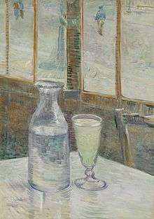A glass and bottle on a cafe table