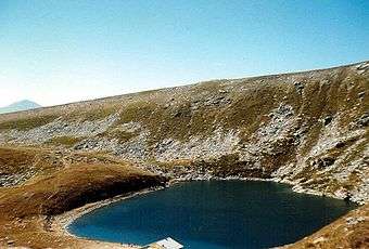 Golemo Ezero surrounded by land scattered with snow