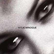 A black-and-white, and motion-blurred image of a woman's (Kylie Minogue) eyes. The song title and woman's name is superimposed on the image.