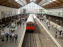 The interior of a building with windows on the ceiling and a railway track running from the background to the foreground in the centre