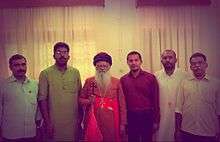 Five men standing around a prelate