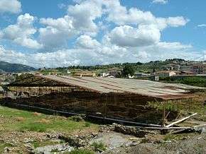 The ruined walls of the villa are covered by a roof to protect them from the elements.