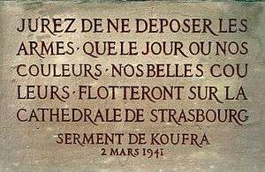 An inscription in stone, in French. It reads: "Jurez de ne déposer les armes que le jour où nos couleurs, nos belles couleurs flotteront sur la cathédrale de Strasbourg. 2 Mars 1941"