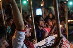 Protesters at night, chanting and holding torches