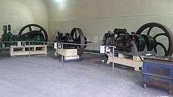 Three heavy oil engines, behind a blue tool box