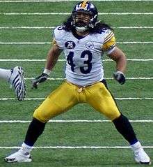 A man wearing white football jersey and yellow pants