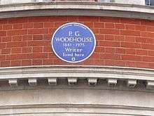 round blue plaque marking Wodehouse's residence, reading: P.G. Wodehouse, 1881–1975: Writer, lived here